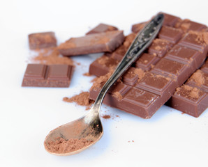 Cocoa powder and dark chocolate isolated on white