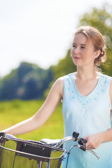 Fototapeta na wymiar Happy Beautiful Blond Woman with Bicycle Outdoors