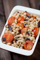 Roasted cherry tomatoes with white beans in a glass bowl