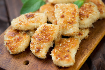 Wooden cutting board with sesame chicken nuggets, studio shot
