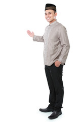 smiling asian muslim man presenting copy space