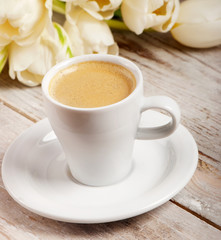 Coffee cup and white tulips