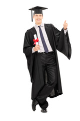 Male graduate holding diploma and giving thumb up