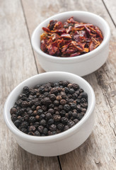 Black pepper on wood background close up