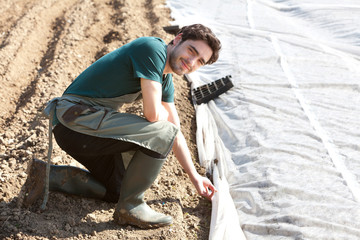 Young attractive farmer verify progress of culture