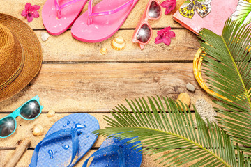 Fototapeta na wymiar Beach, palm tree leaves, sand, sunglasses and flip flops