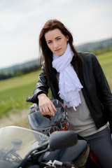 Fototapeta na wymiar cheerful and beautiful young woman riding motorbike