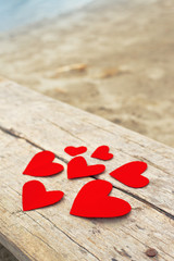 Red paper hearts on grunge wooden background