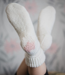 White hand knitted woolen socks witn a pink heart
