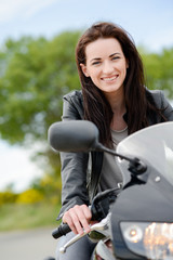 cheerful and beautiful young woman riding motorbike