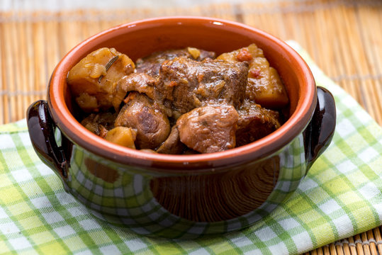 Spezzatino di carne con patate e funghi in una tegame di coccio