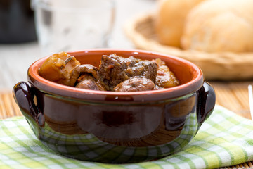 Spezzatino di carne con patate e funghi in una tegame di coccio