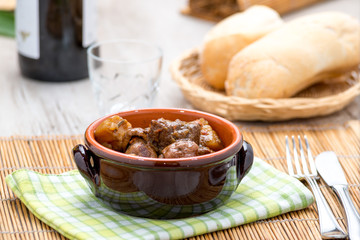 Spezzatino di carne con patate e funghi in una tegame di coccio