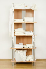Fototapeta na wymiar Schludny szafa z białego ubrania ładnie ułożone na półce.