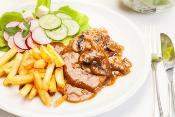 Pork chop with sauce, mushrooms and chips