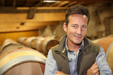 Portrait of winemaker standing in wine cellar