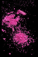Pink makeup powder explosion suspension on black background