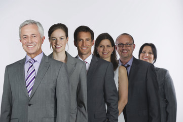 Geschäftsleute stehen in Zeile vor weißem Hintergrund,lächelnd