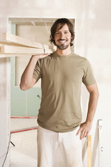 Junger Mann mit Schnittholz,lächelnd,Porträt