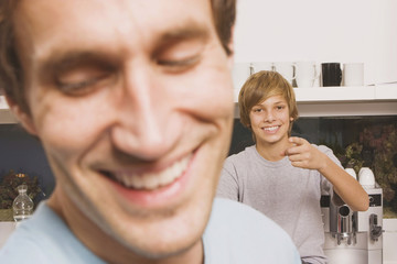 Obraz premium Vater und Sohn ( 13-14),Mann lächelnd,Junge zeigt,close up