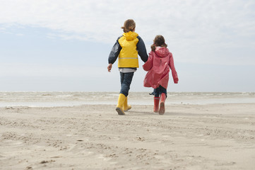Deutschland,St. Peter-Ording,Nordsee,Junge und Mädchen (6-9) den Händen halten und zu Fuß am Strand