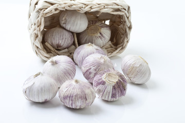 Chinesische Knoblauchzwiebeln im Korb auf weißem Hintergrund