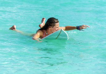 Attractive Young girl on surfboard in ocean