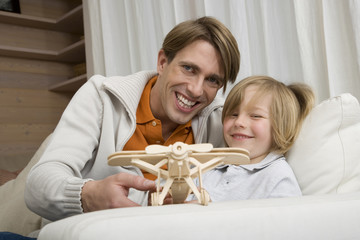 Vater und Sohn ( 8-9 ) spielen mit Modellflugzeug,Portrait