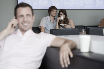 Fototapeta premium Deutschland,Köln,Paar im Café,Mann im Vordergrund mit Handy