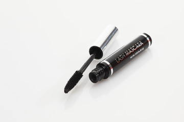 Offene Mascara Flasche mit Pinsel auf weißem Hintergrund