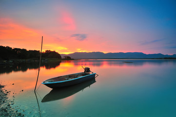 Fototapeta na wymiar Lonely boat by the lakeside during beautiful sunset