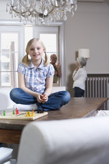 Mädchen (8-9) lächelnd,Porträt,Großeltern im Hintergrund