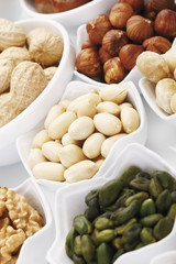 Verschiedene Nüsse in der Schale auf weißem Hintergrund