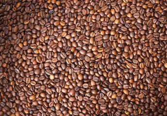 Numerous coffee beans which have been scattered all over the sur