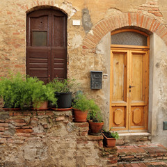 Fototapeta na wymiar doorsteps decorated with flowerpots to the tuscan house