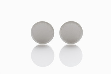 Zwei weiße Tabletten auf weißem Hintergrund, close up