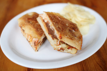 Meatball sandwich with potato chips.