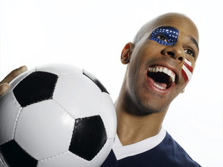 Mann mit USA-Flagge auf Gesicht gemalt , hält Fußball