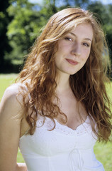 Junge Frau im weißen Kleid steht im Garten,lächelnd,close-up,Portrait
