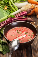 Beetroot soup with egg and vegetables in a bowl