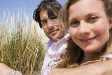 Obraz premium Deutschland,Ostsee,Junges Paar sitzt in den Dünen,Portrait