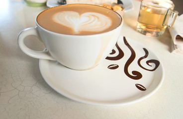 Cup of coffee with heart pattern in a white cup