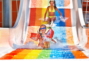Child on water slide at aquapark.