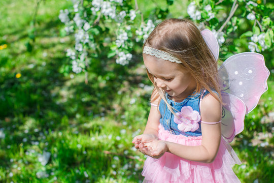 Little girl with a ladybug in the hands at flowering apple