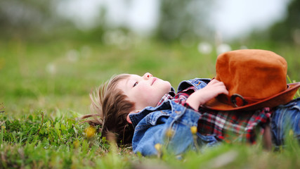 Happy smiling boy dressed in country style playing in the park