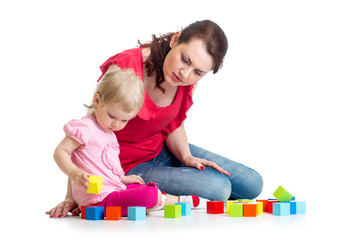 Fototapeta na wymiar child girl and her mom play with building blocks