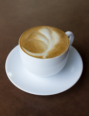 Cup of art latte on a cappuccino coffee