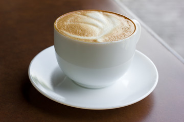 Cup of art latte on a cappuccino coffee