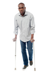 African man with crutches trying to walk
