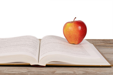 Open book with apple isolated on white background